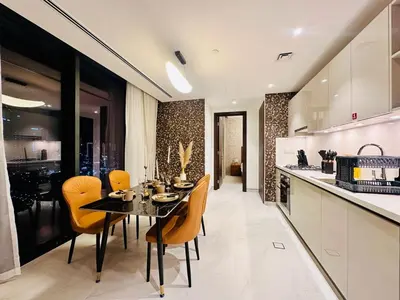 a kitchen and dining room with a table and chairs at Brand New 1BR in Creek Vista Grande in Dubai