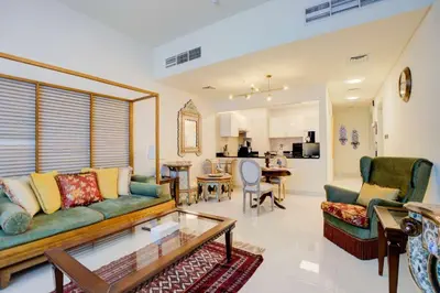a living room with a couch and a table at Elegant 1BR in Polo Residences Nad Al Sheba in Dubai