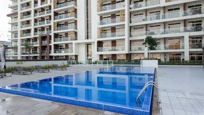 a swimming pool in front of a large apartment building at Stylish Pool-View Studio w Balcony & King Bed in Dubai