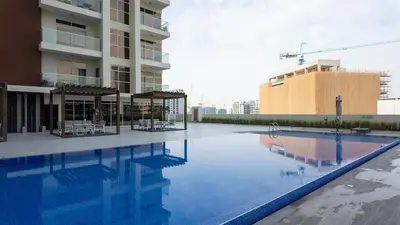 a swimming pool in front of a building at Stylish Pool-View Studio w Balcony & King Bed in Dubai