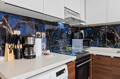 a kitchen with a counter with a stove top oven at Stylish Pool-View Studio w Balcony & King Bed in Dubai