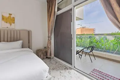 a bedroom with a bed and a balcony with a view at Stylish Pool-View Studio w Balcony & King Bed in Dubai