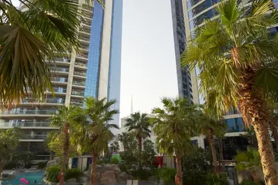a group of palm trees in front of tall buildings at Stylish 2BR Paramount Tower D in Dubai