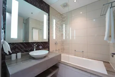 a bathroom with a sink and a tub at Stylish 2BR Paramount Tower D in Dubai