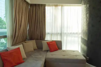 a living room with a white couch with colorful pillows at Stylish 2BR Paramount Tower D in Dubai