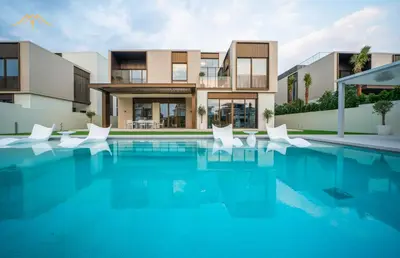 a house with a swimming pool with white chairs at New Arabian Palm Hills 6BR & Maid & Private Pool in Dubai