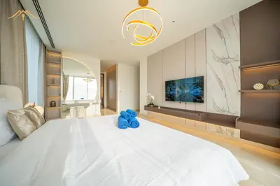 a bedroom with a large white bed and a tv at New Arabian Palm Hills 6BR & Maid & Private Pool in Dubai