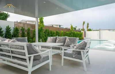 a white table and chairs with an umbrella on a patio at New Arabian Palm Hills 6BR & Maid & Private Pool in Dubai