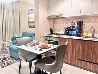 a kitchen with a table and chairs and a kitchen with a kitchen at 01BR apartment in DAMAC Vera Residences in Dubai
