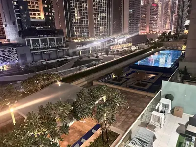 an overhead view of a city at night with a pool at 01BR apartment in DAMAC Vera Residences in Dubai