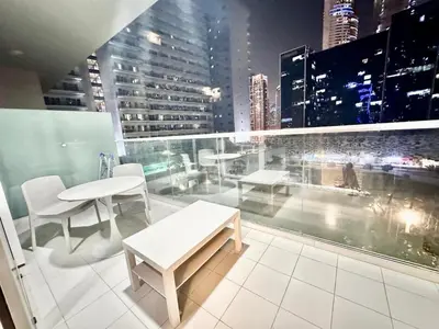 a balcony with tables and chairs on a building at 01BR apartment in DAMAC Vera Residences in Dubai
