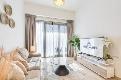 a living room with a couch and a tv at Bright & Stylish Home in the Heart of Meydan in Dubai