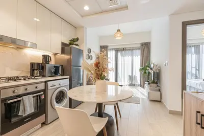 a kitchen and dining room with a table and chairs at Bright & Stylish Home in the Heart of Meydan in Dubai