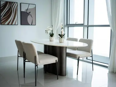 a dining room with a white table and chairs at Marina Beachfront Oasis Infinity Pool & Modern Comfort in Dubai