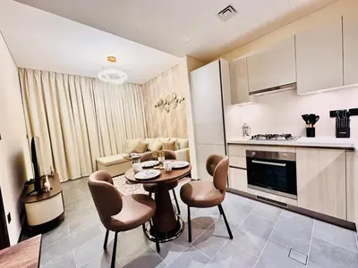 a kitchen and living room with a table and chairs at Modern Fully Furnished 1BR plus Study in Crest Tower B in Dubai