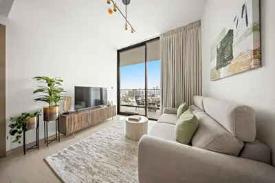a living room with a couch and a tv at FIRST CLASS 1BR Urban Living Comfort in Dubai