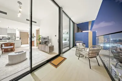a living room with large glass windows and a kitchen at FIRST CLASS 1BR Urban Living Comfort in Dubai
