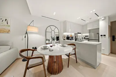 a kitchen and living room with a table and chairs at FIRST CLASS 1BR Urban Living Comfort in Dubai