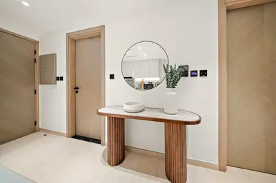 a round mirror on a wooden table in a room at FIRST CLASS 1BR Urban Living Comfort in Dubai