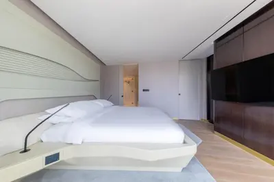 a bedroom with a white bed and a flat screen tv at The Opus Residences Luxury Design in Dubai