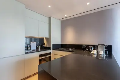 a kitchen with a large black counter top at The Opus Residences Luxury Design in Dubai