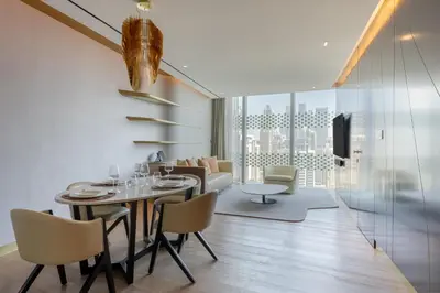 a dining room and living room with a table and chairs at The Opus Residences Luxury Design in Dubai