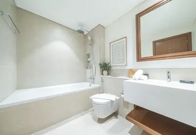 a bathroom with a tub and a toilet and a sink at 1 Bed in Palace Beach Residence with sea view in Dubai