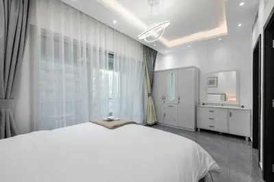 a bedroom with a white bed and a window at Dubai Marina - Comfy 1BHK Apartment in Dubai