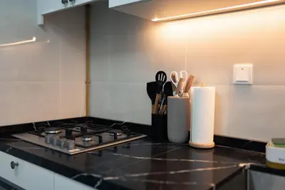 a kitchen counter with a stove and some knives at Dubai Marina - Comfy 1BHK Apartment in Dubai