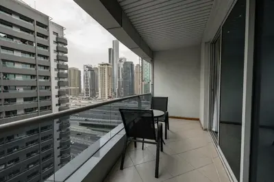 a balcony with two chairs and a table in a building at Dubai Marina - Comfy 1BHK Apartment in Dubai
