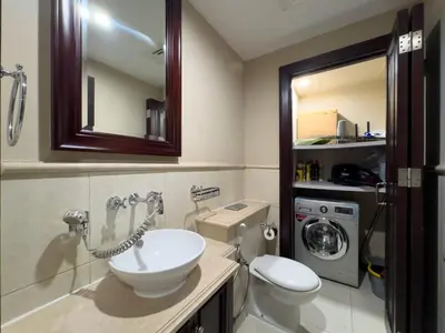 a bathroom with a sink and a toilet and a mirror at Werova - Spacious 1-Bedroom Apartment for Rent in Dubai