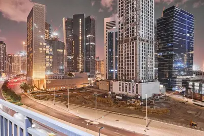 a city skyline at night with tall buildings at Compact 1 BHK Apartment in Dubai