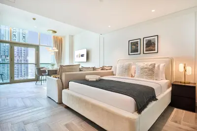 a bedroom with a large bed and a living room at Stylish Studio in the Heart of DIFC in Dubai