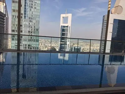 a swimming pool on the roof of a building with tall buildings at Stylish Studio in the Heart of DIFC in Dubai