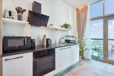 a kitchen with a microwave and a stove top oven at Stylish Studio in the Heart of DIFC in Dubai