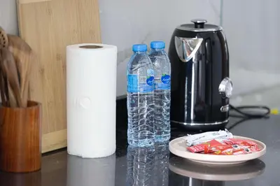 two bottles of water and a roll of paper towels at Stylish Silicon Oasis Studio Near Mall & Airport in Dubai
