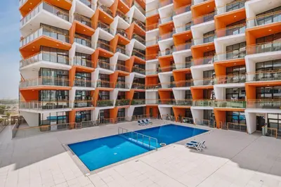 an apartment building with a swimming pool in front of it at Stylish Silicon Oasis Studio Near Mall & Airport in Dubai