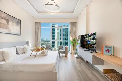a living room with a large bed and a television at Livin' Holidays -Studio - Azizi Magnificent Studio in Dubai