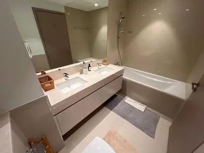 a bathroom with two sinks and a large mirror at SKYLiNE - 4 BR - BURJ KHALiFA & FOUNTAiN ViEW in Dubai