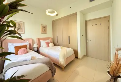 a bedroom with two beds and a sliding door at SKYLiNE - 4 BR - BURJ KHALiFA & FOUNTAiN ViEW in Dubai