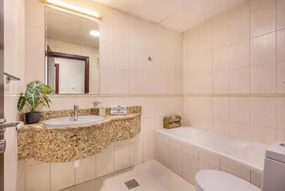 a bathroom with a sink and a tub and a toilet at Central Spacious Marina Home on the 64th Floor in Dubai
