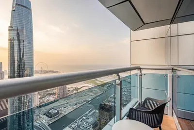 a balcony with two chairs and a view of the city at Central Spacious Marina Home on the 64th Floor in Dubai
