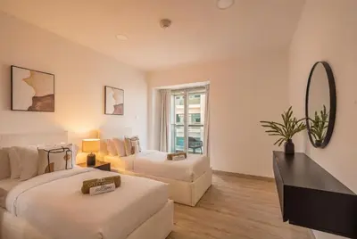 a hotel room with two beds and a mirror at Central Spacious Marina Home on the 64th Floor in Dubai