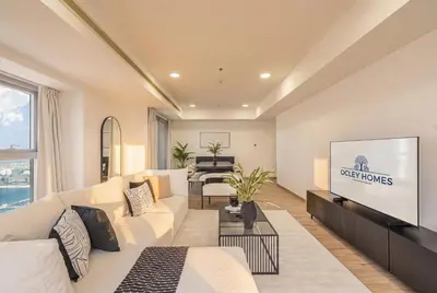 a living room with a white couch and a tv at Central Spacious Marina Home on the 64th Floor in Dubai