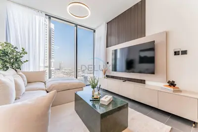 a living room with a couch and a tv at Prime 1BR, Few minutes Drive to Burj Khalifa and Dubai Mall - Sobha Hartland The Crest Tower C by Deluxe Holiday Homes in Dubai