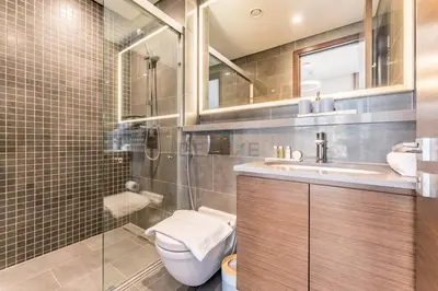 a bathroom with a toilet and a sink and a shower at Prime 1BR, Few minutes Drive to Burj Khalifa and Dubai Mall - Sobha Hartland The Crest Tower C by Deluxe Holiday Homes in Dubai