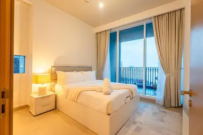 a bedroom with a bed and a large window at 1BR Lake & Harbour View Dubai Creek Harbour in Dubai