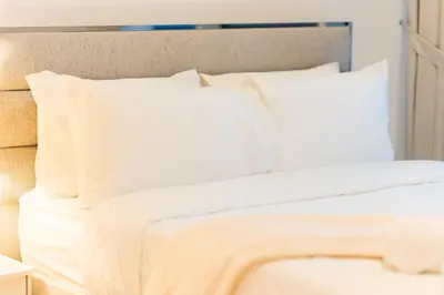 a white bed with white sheets and pillows at 1BR Lake & Harbour View Dubai Creek Harbour in Dubai