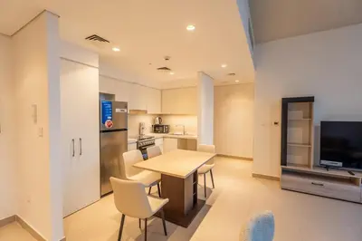a kitchen and dining room with a table and chairs at 1BR Lake & Harbour View Dubai Creek Harbour in Dubai