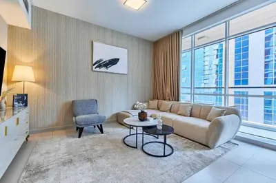 a living room with a couch and a chair at Bright 2 BHK in Prime Location in Dubai